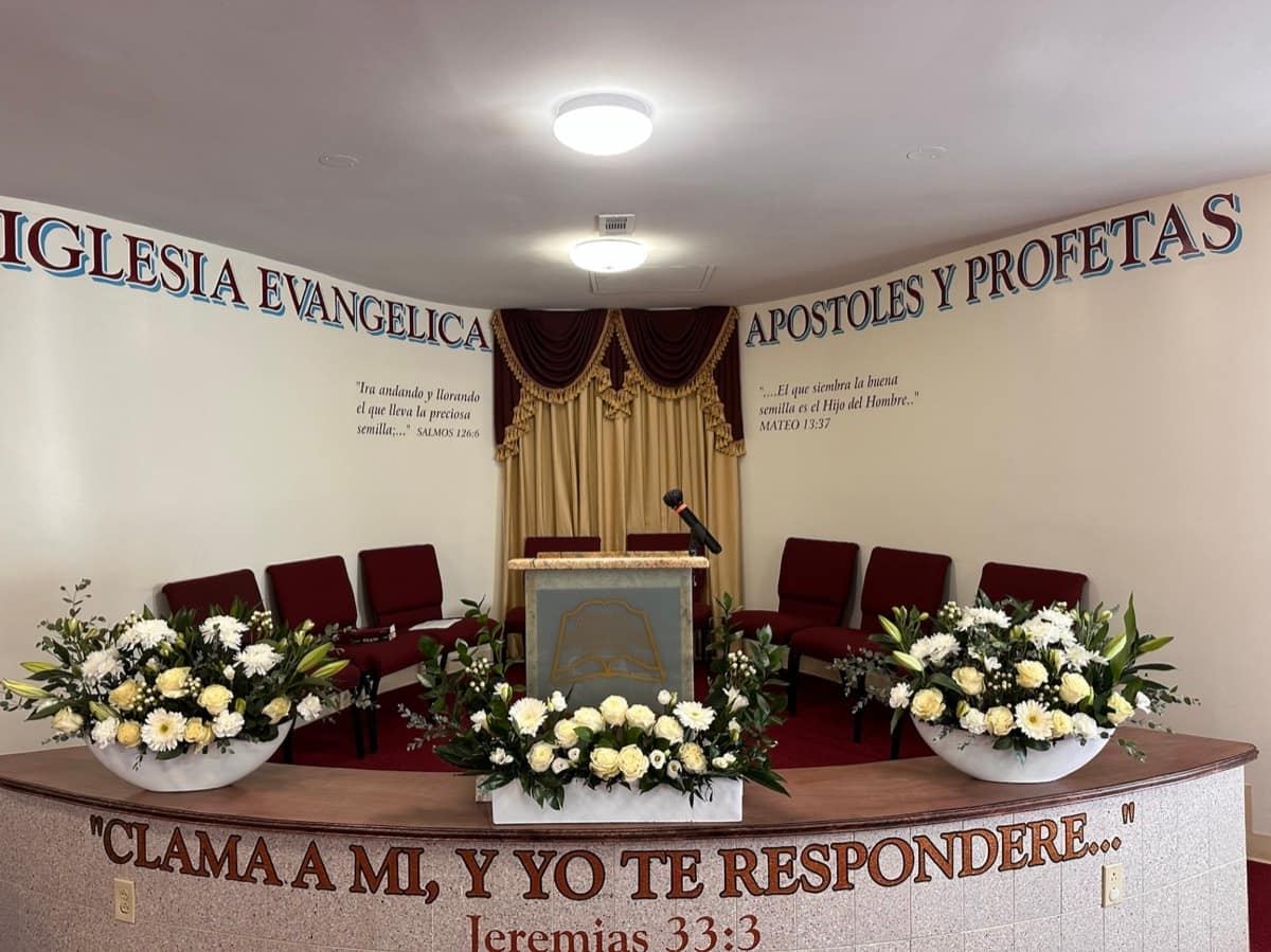 Church sanctuary decorated with coordinated floral arrangements