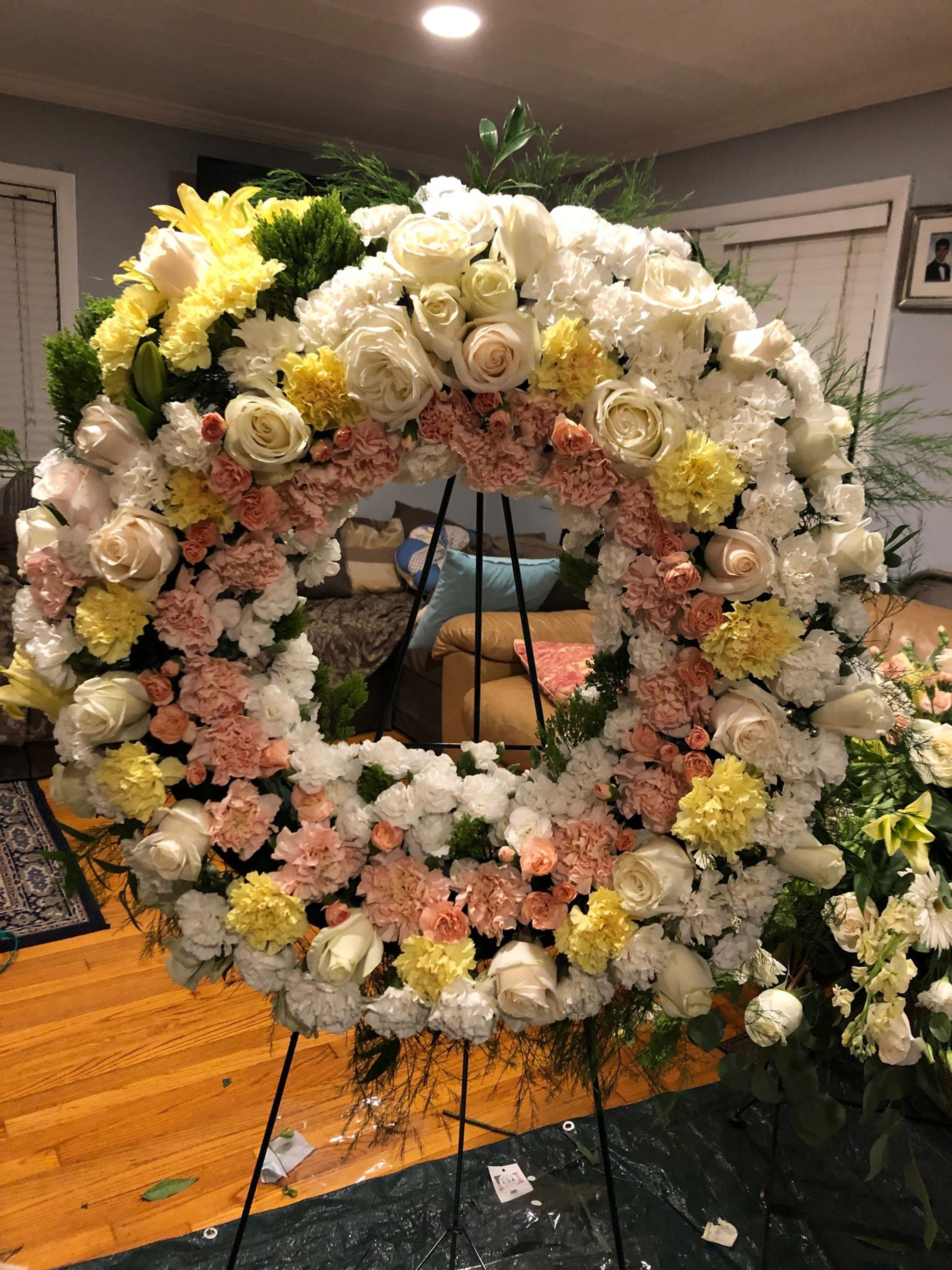 Large yellow, peach, and white memorial wreath