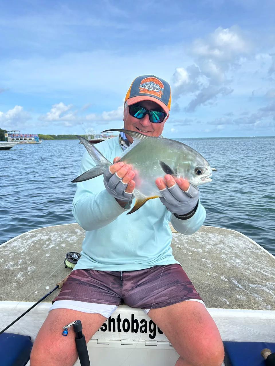 A permit held in both hands over the gunwale