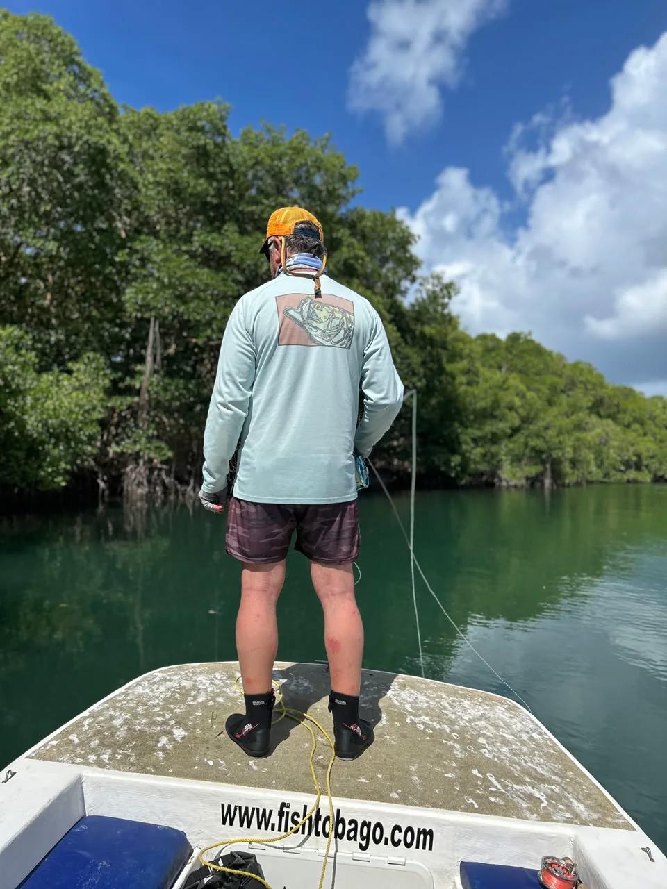 An angler casting a fly line along the mangrove edge