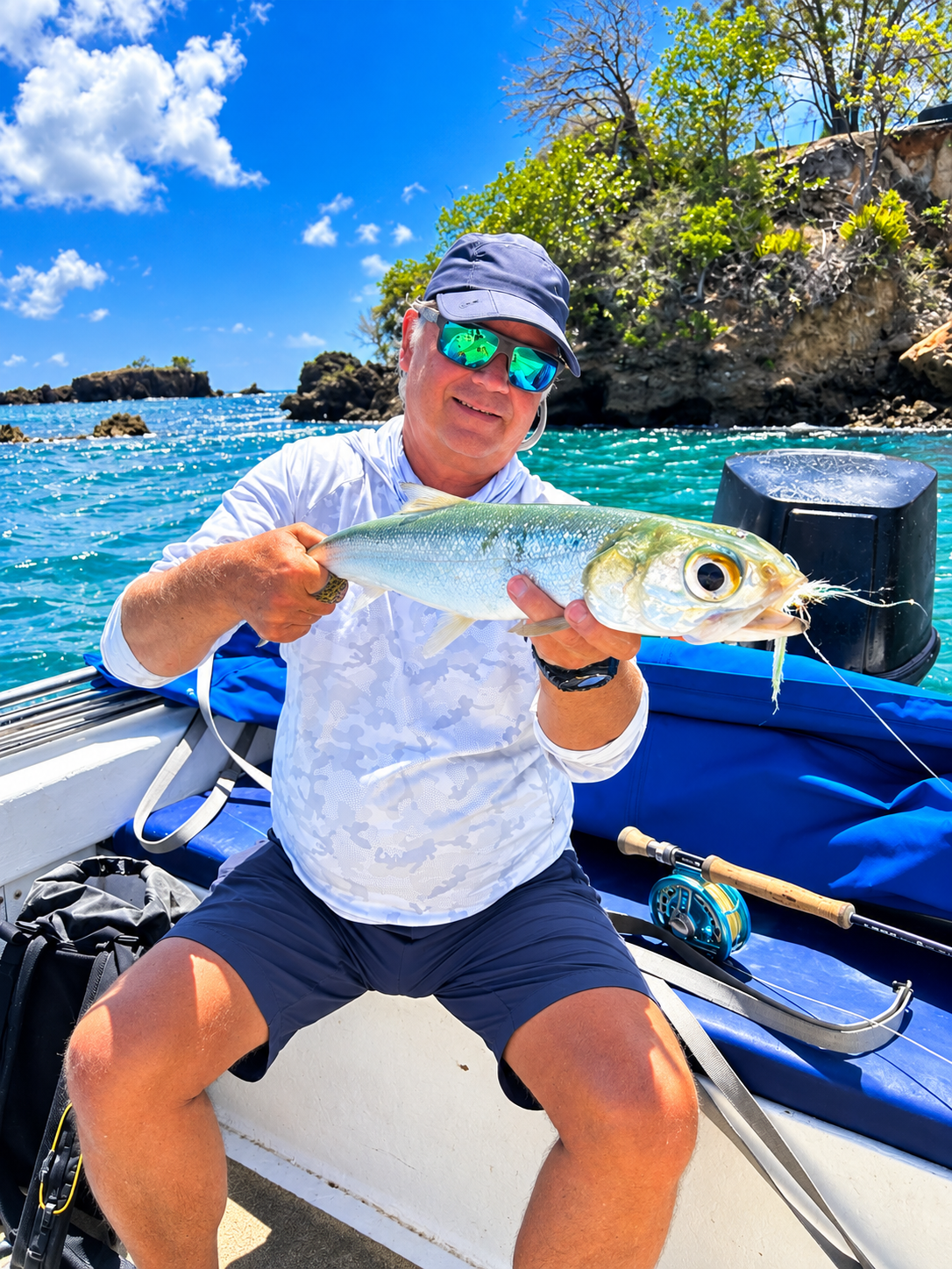 A ladyfish held low over the water before release