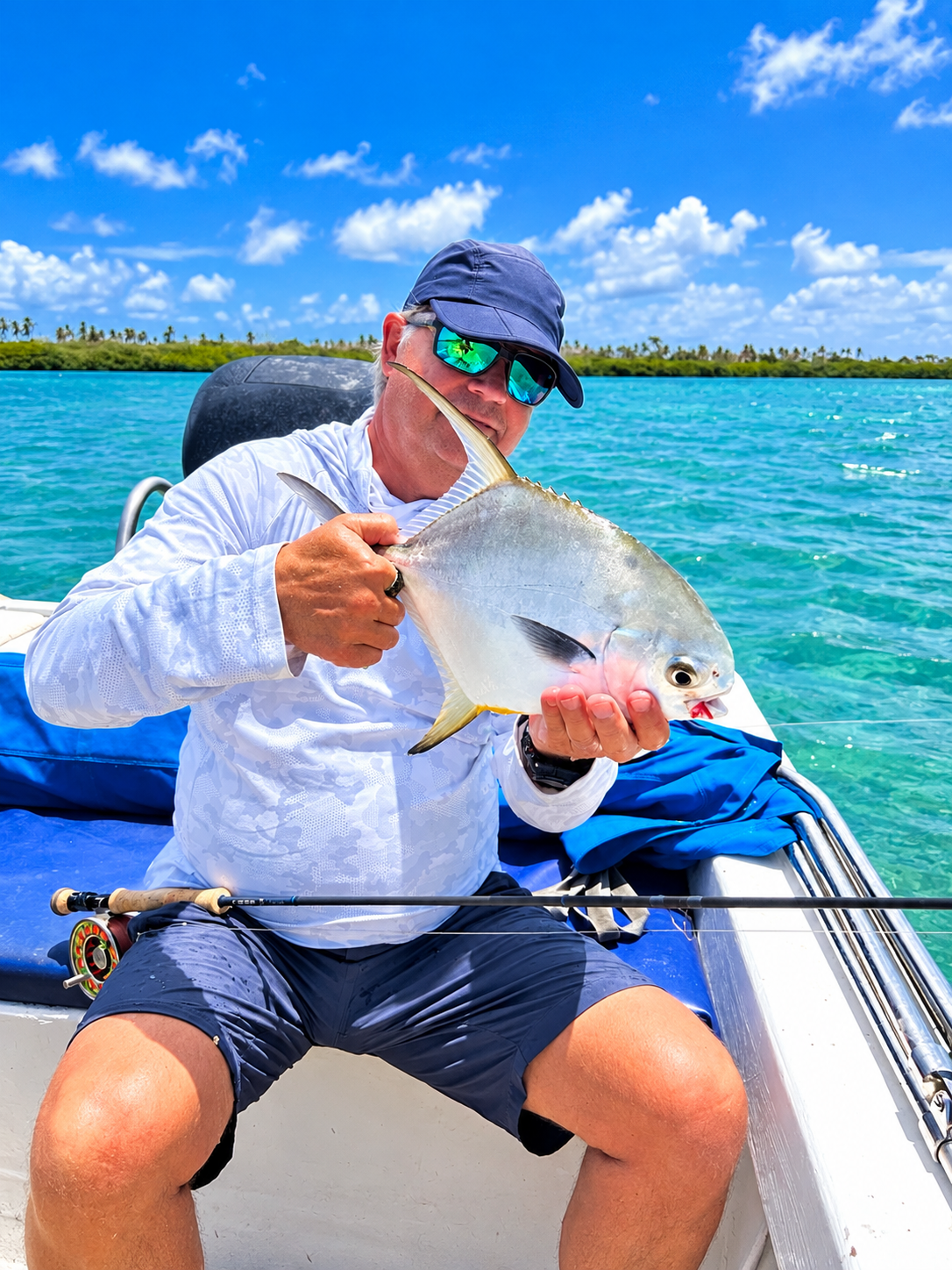 A permit held in both hands over the gunwale