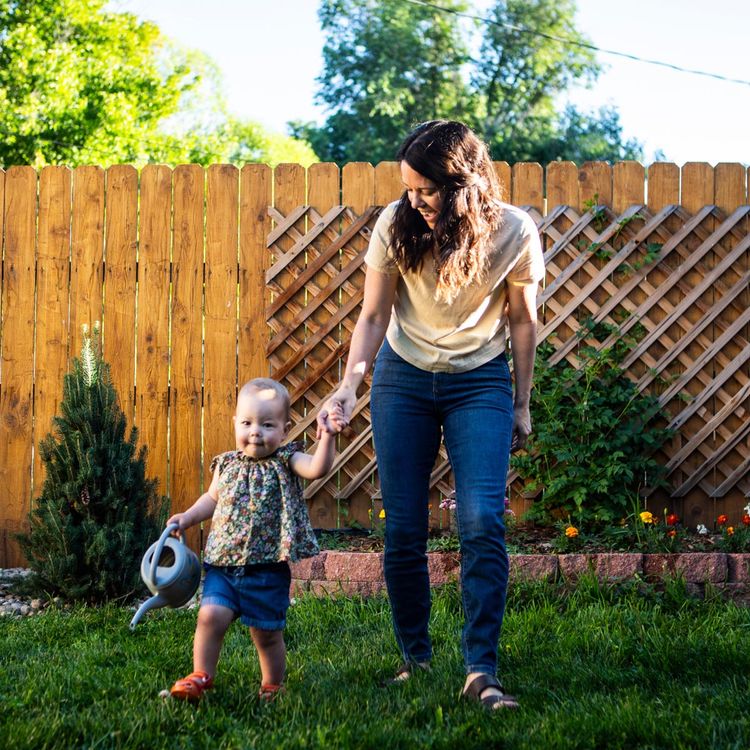 Woman and child enjoying green grass in their yard