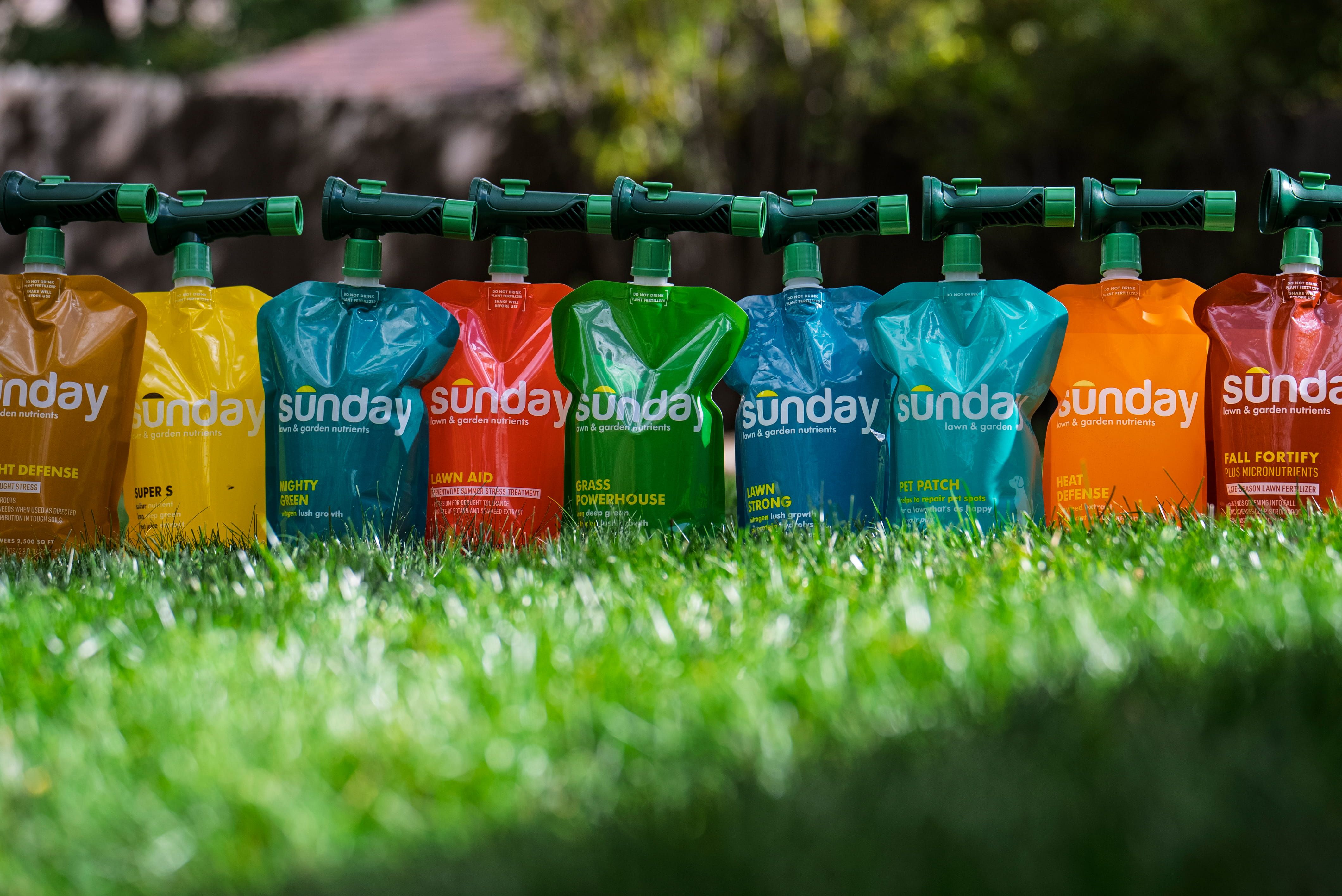 Sunday lawn fertilizer pouches in a line on a green lawn