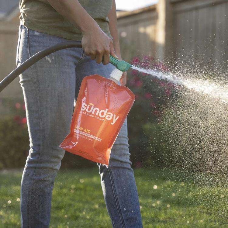 woman spraying lawn aid
