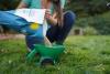 A woman pouring grass seed into a spreader