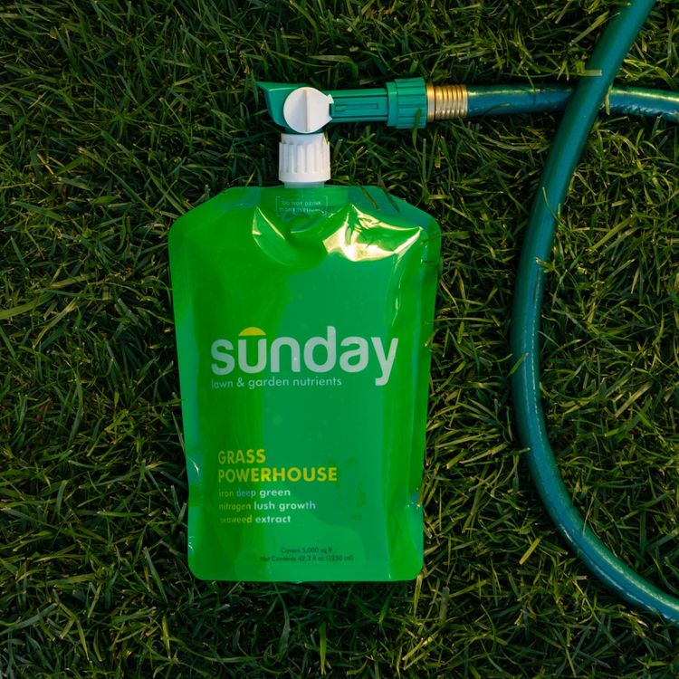 Grass Powerhouse on the grass attached to a hose and ready to spray