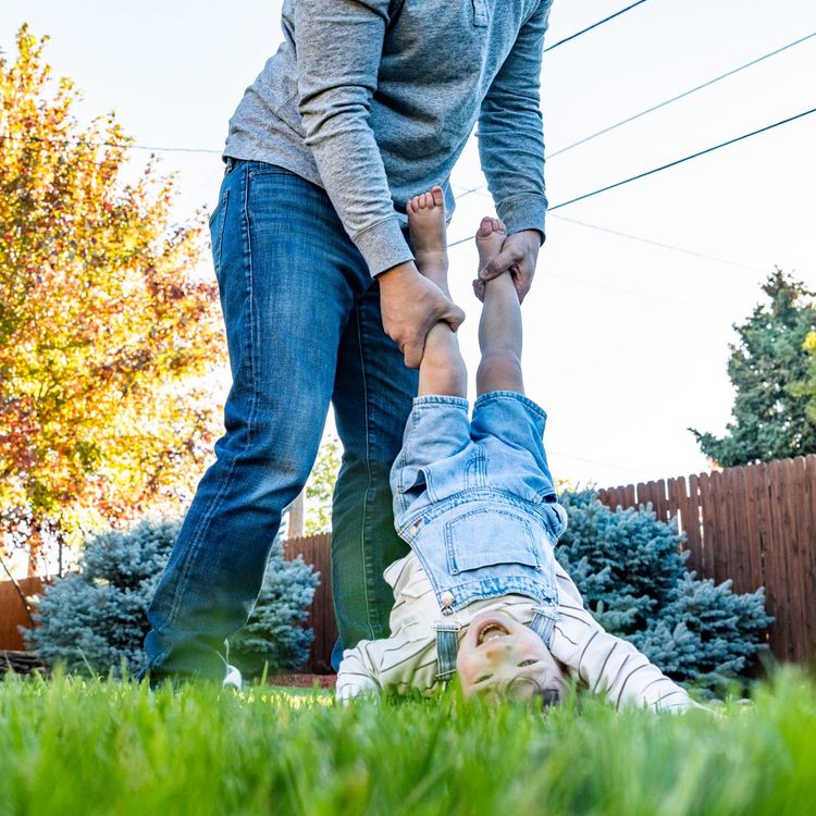 Child and parent playing in green grass