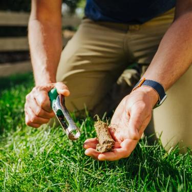 Man taking soil sample of lawn with Sunday soil test kit.