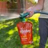 Man using Sunday lawn fertilizer sprayer hose-end sprayer to apply liquid fertilizer on lawn