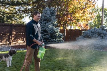Man applying Sunday pet plan nutrients to lawn.