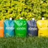 Sunday lawn fertilizer pouches in a line on a green lawn