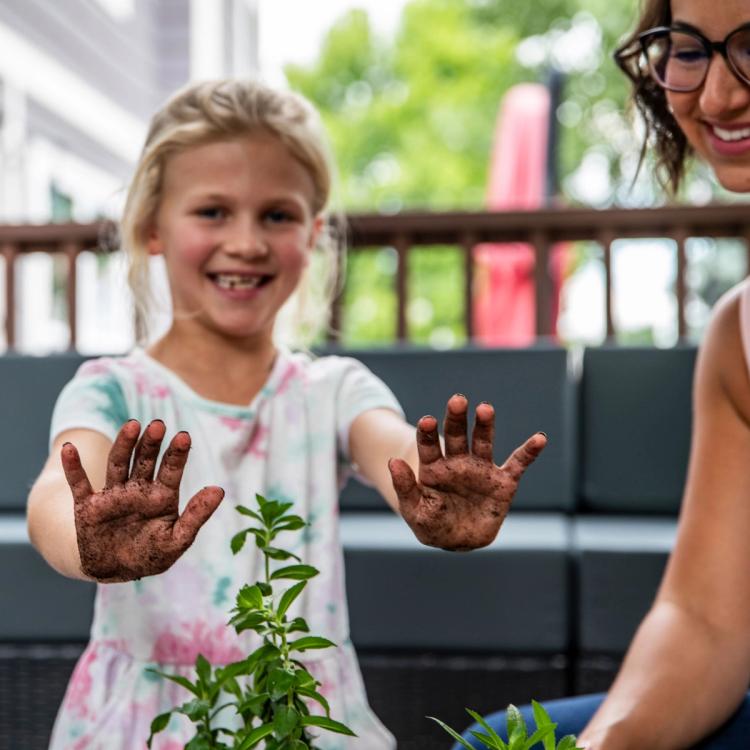 Child smiling with dirty hands from planting