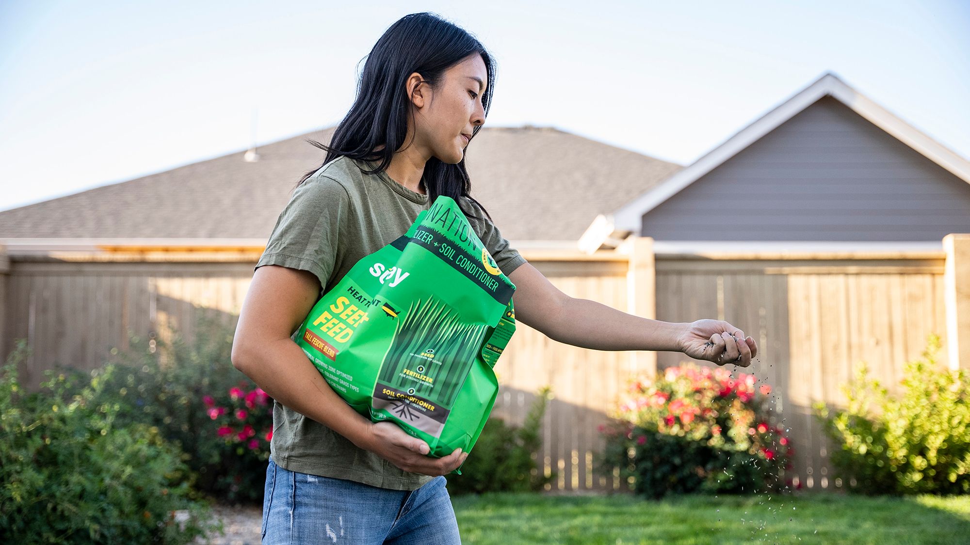 Woman spreading seed on lawn