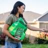 Woman spreading seed on lawn
