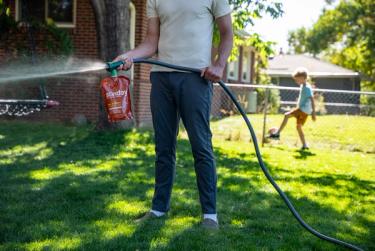 Applying Sunday Fall Fortify fertilizer to warm-season grass during fall lawn care for warm-season grasses.