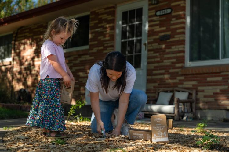 Woman and daughter collecting a garden soil sample