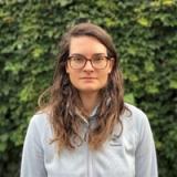 Photo of Maggie Reiter, lead turf scientist at Sunday looking at turfgrass