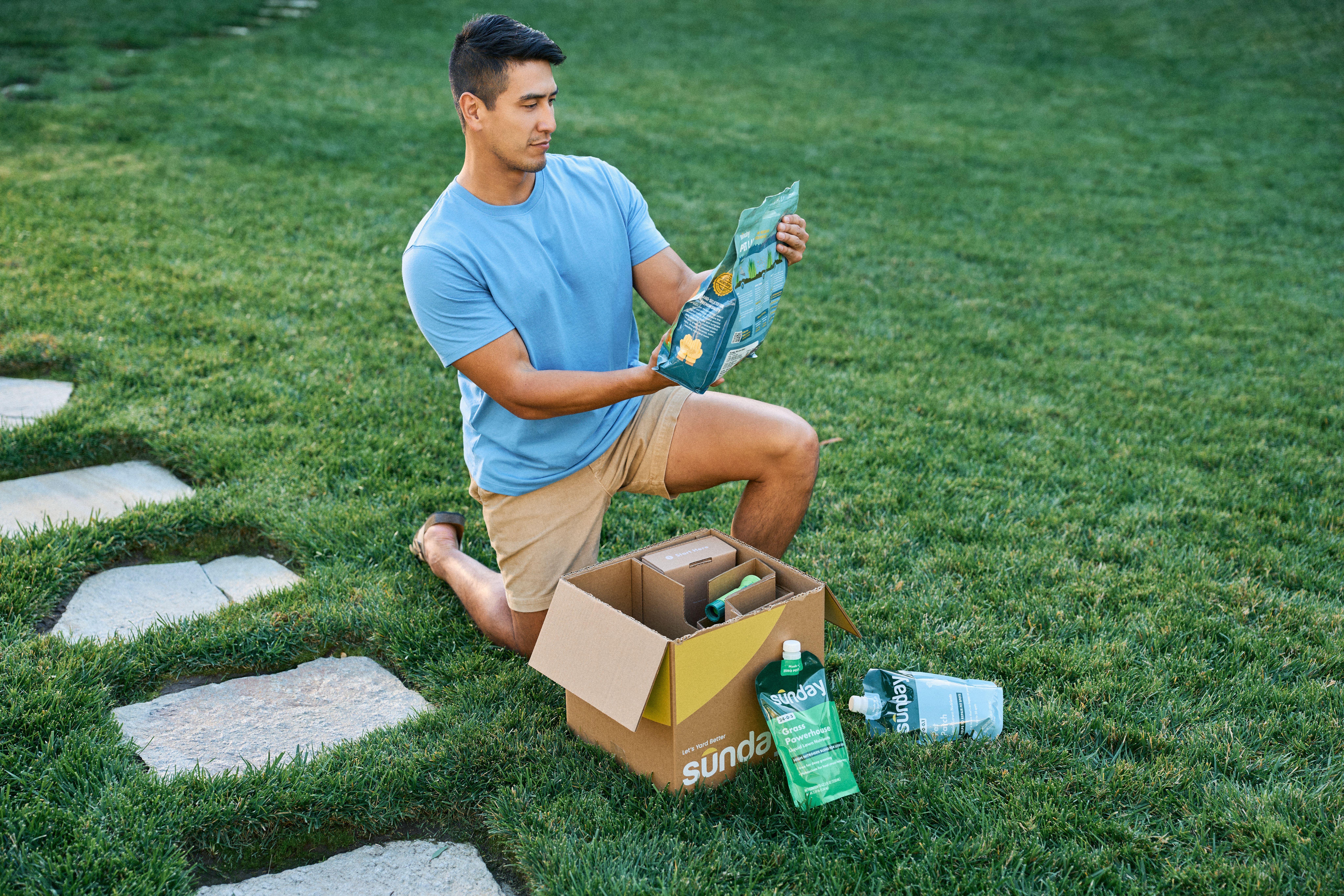 Person opening Sunday subscription box in his yard