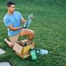 Person opening Sunday subscription box in his yard