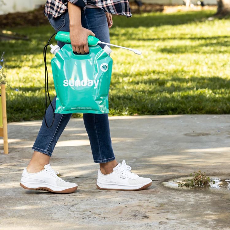 Woman carrying herbicide pouch and sprayer