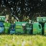 Lineup of Sunday liquid fertilizers, pest control, and grass seed products on a green lawn.