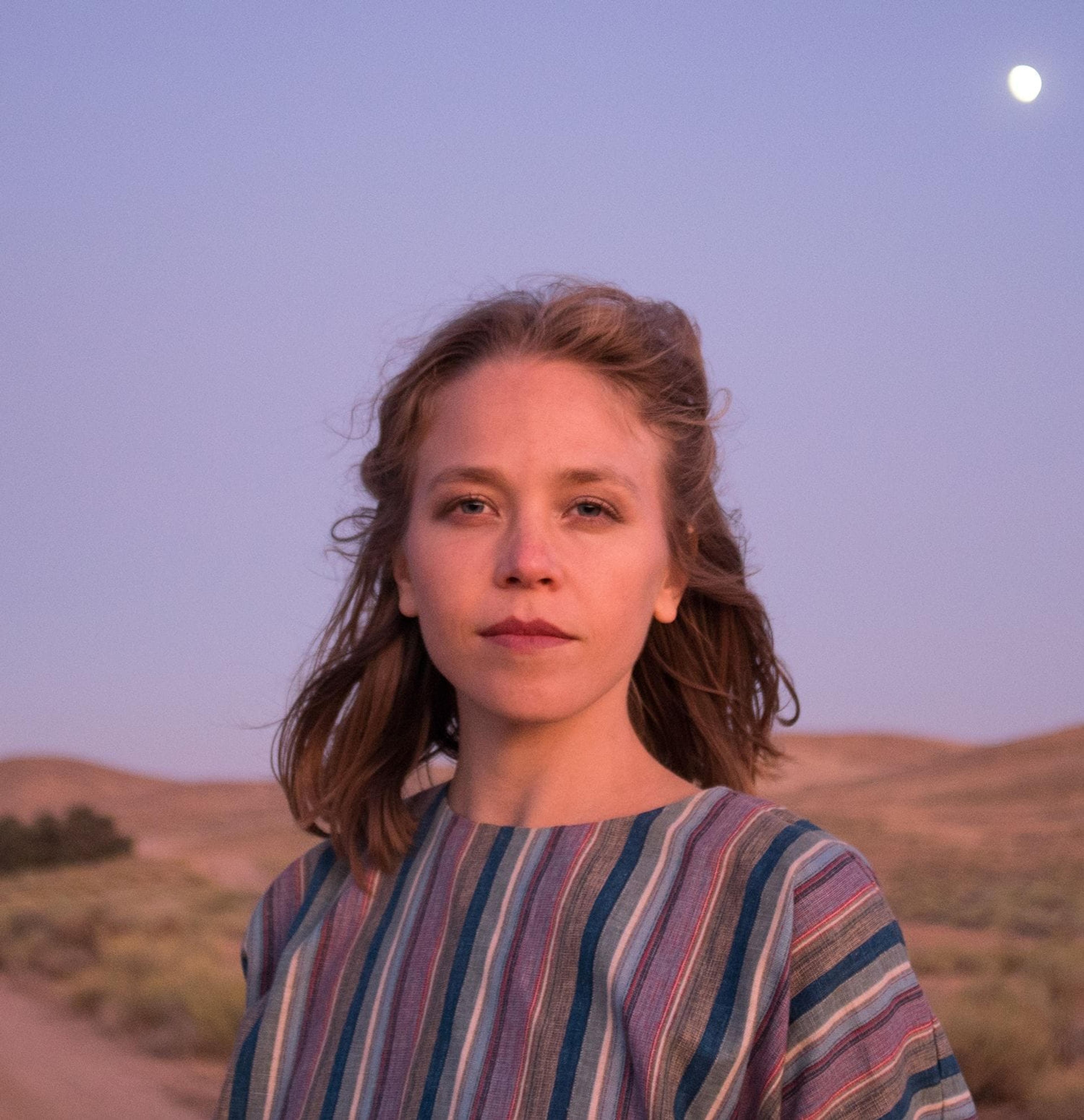 Portrait photograph of Lara Marcin in front of a deserted landscape