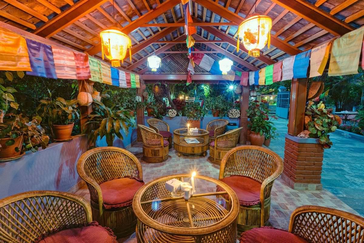 Cane chairs in the garden pavilion, under prayer flags