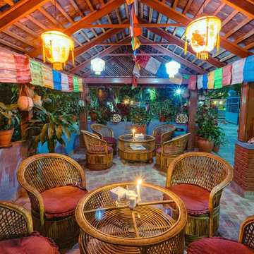 Cane chairs in the garden pavilion, under prayer flags