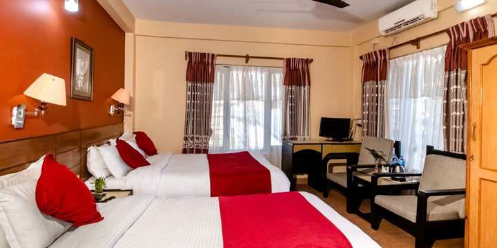 A guest room with a double bed and a sitting area