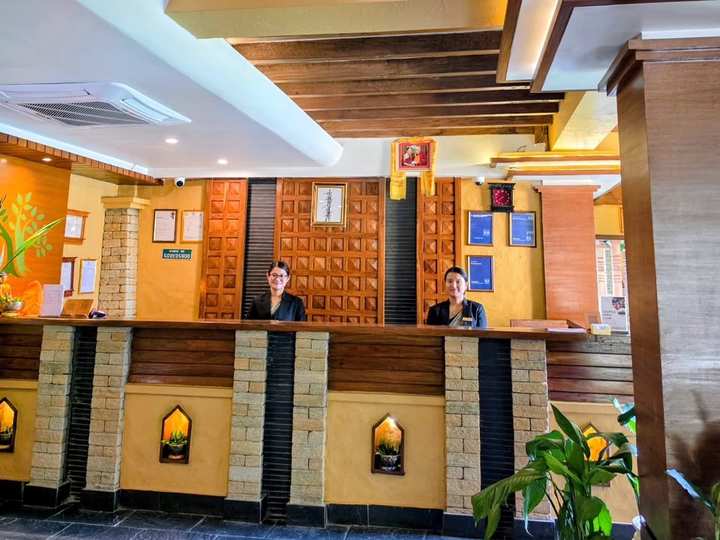 Two of the reception team at the front desk, under the timber beams
