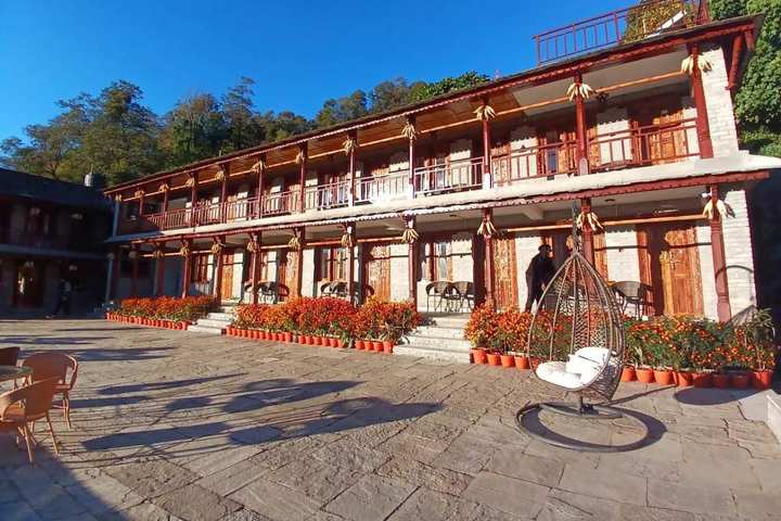 The two storeys of stone and timber, with marigolds along the front