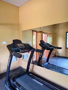 A treadmill in front of the mirror wall