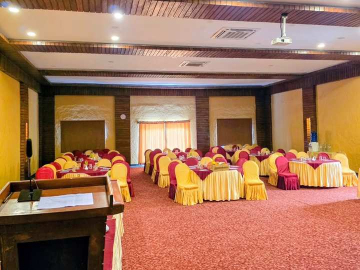 The hall laid with round tables for a function, a lectern in the foreground