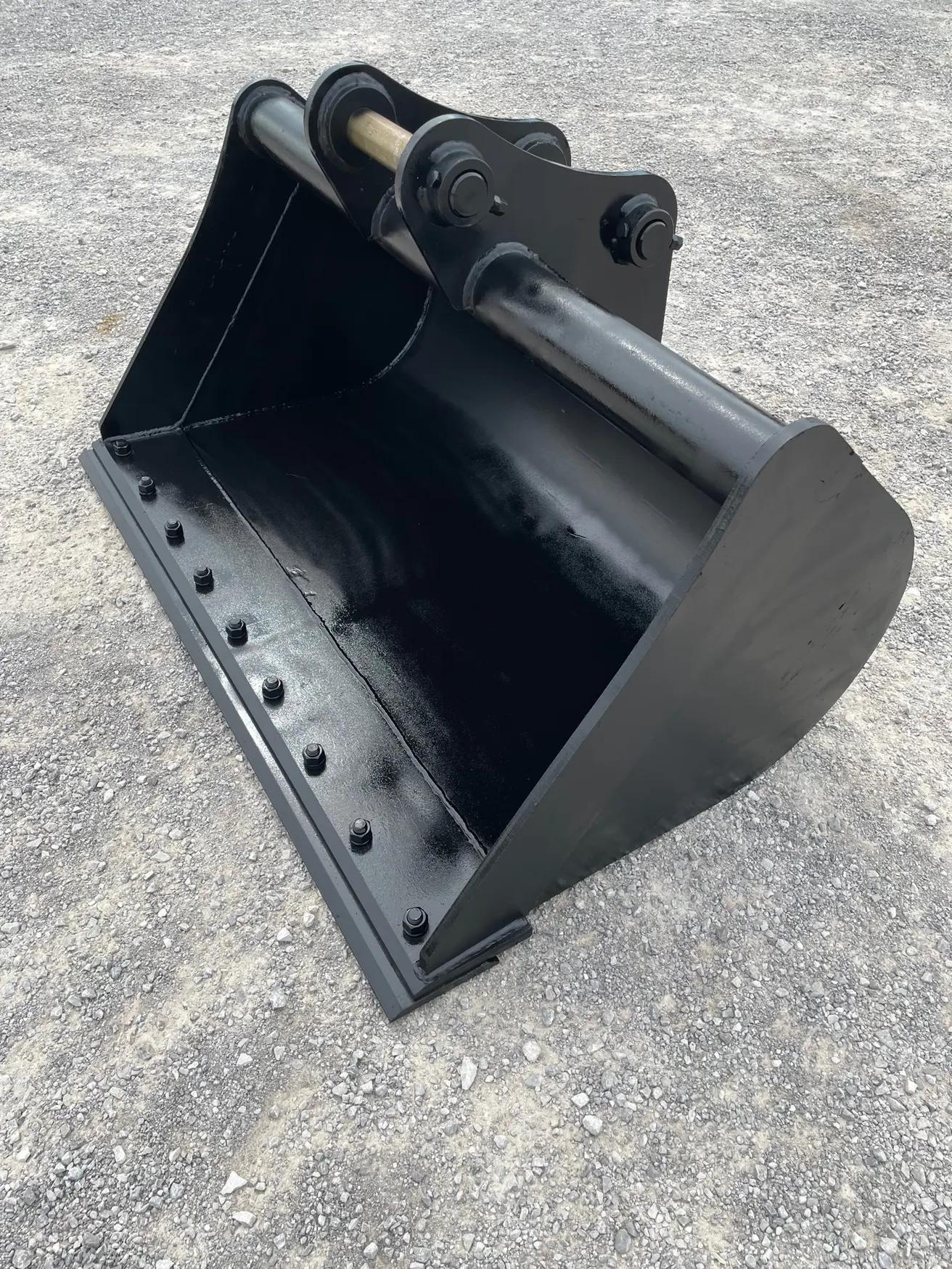 black ditch-cleaning bucket on a gravel lot