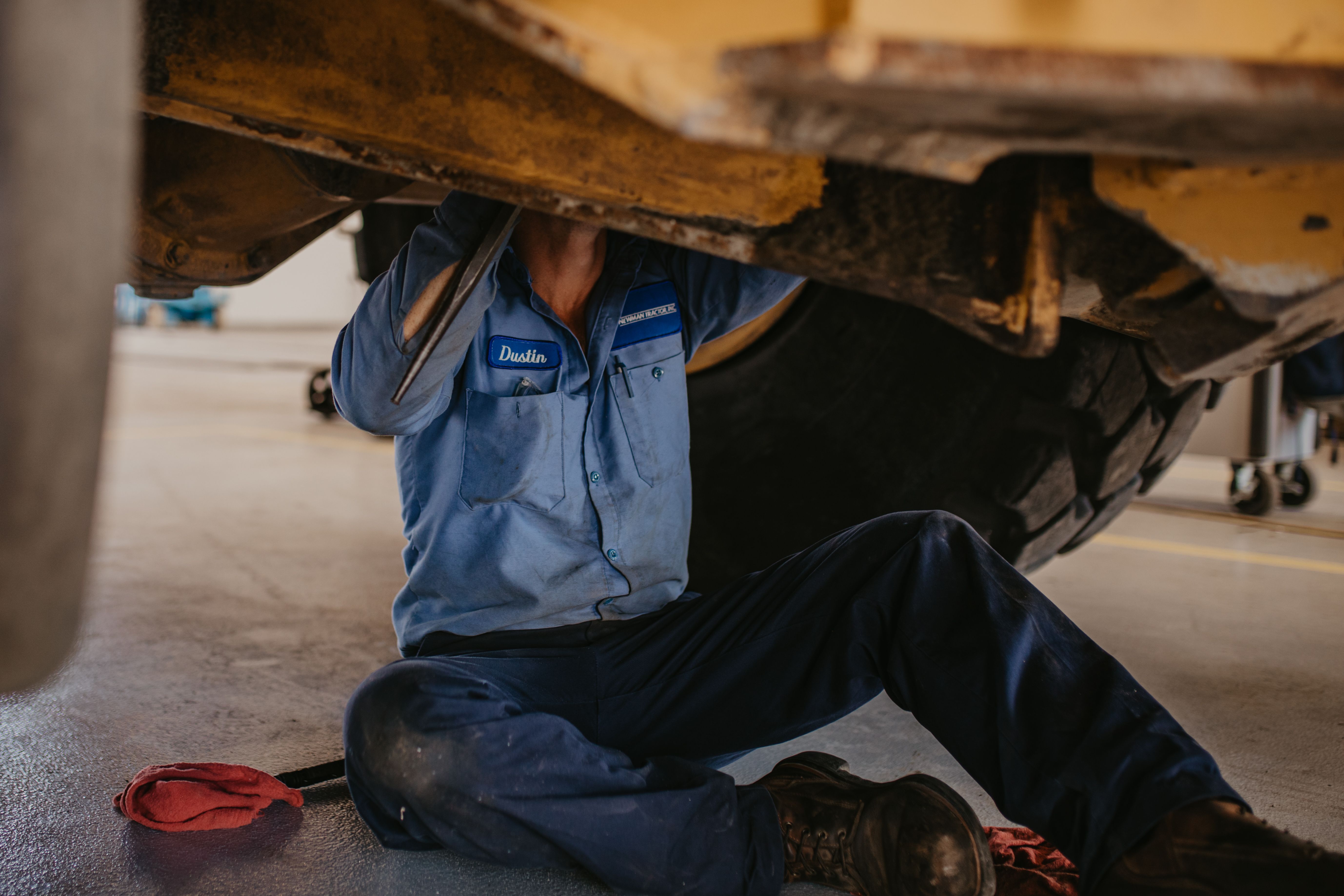 technician working under heavy equipment