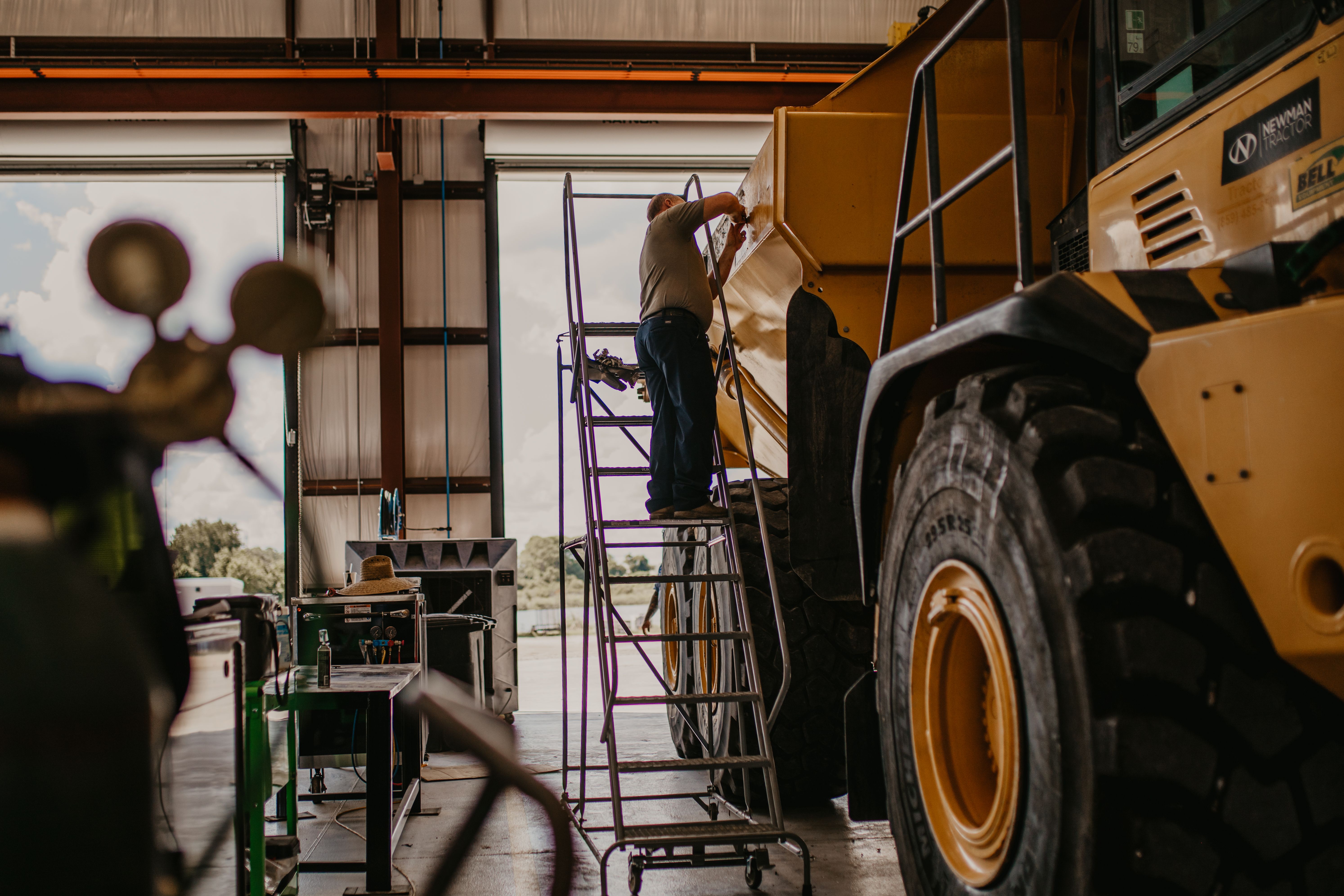 a technician working on a Bell articulated dump truck