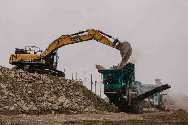 Large excavator dumping rubble
