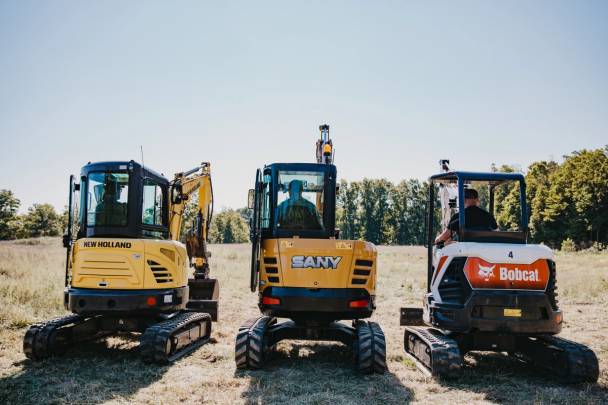 Three mini excavators in a field