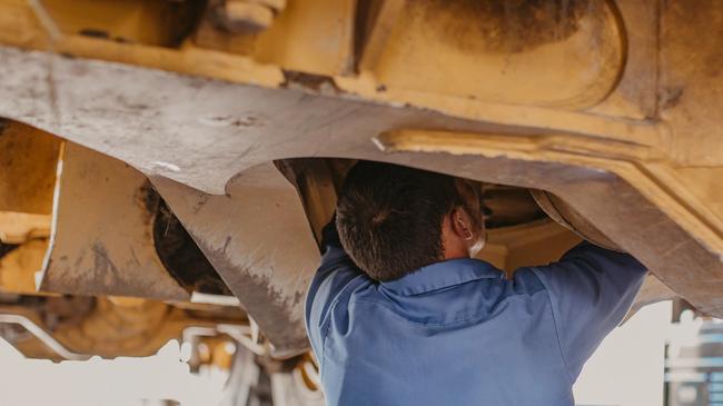technician working under heavy machinery