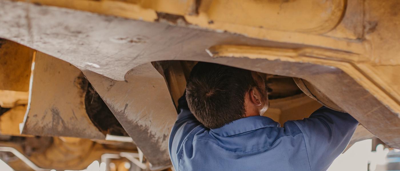 technician working under heavy machinery