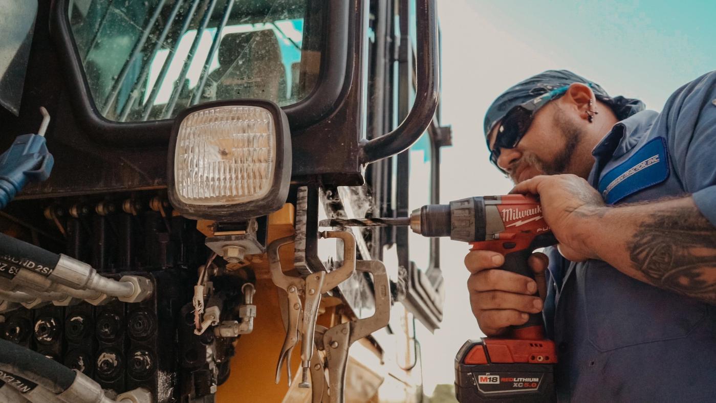 heavy equipment repair man drilling - Background Image