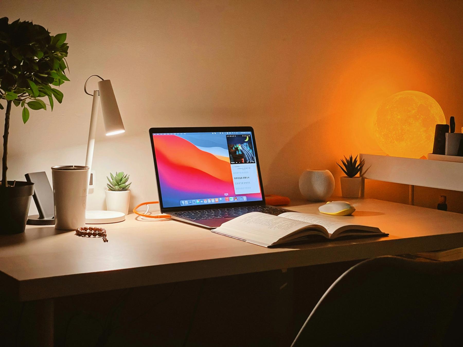 Bureau avec pleins d'éléments comme un ordinateur, des cahiers et des documents.