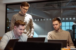 Tre menn som ser på pc