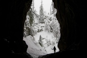 Person ved utgangen av en snøfylt hule