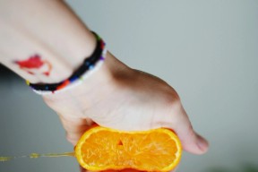 hånd skviser en appelsin