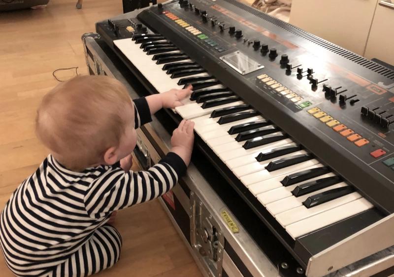 Child playing a way too expensive synthesizer