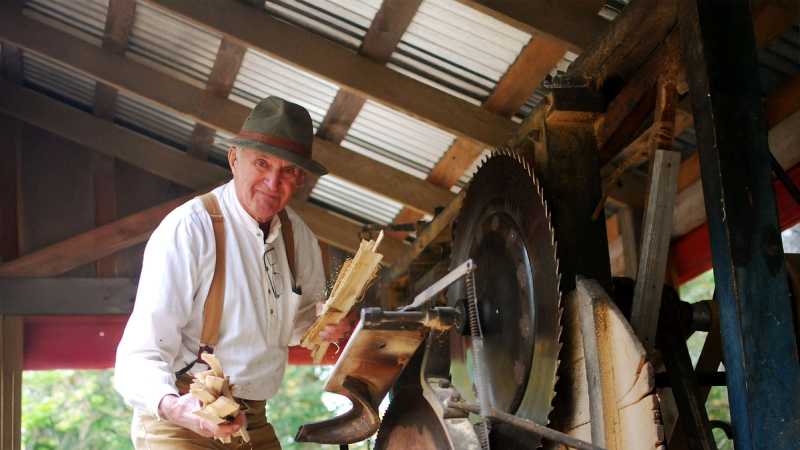 Volunteer working the shingle mill at a museum event.