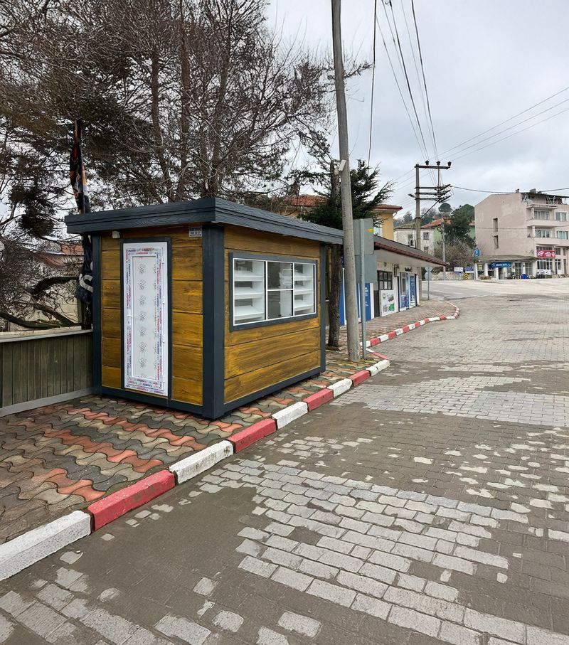 Metro City kiosk clad in timber-effect panels with a glazed display window and bakery shelving, sited on a town pavement.