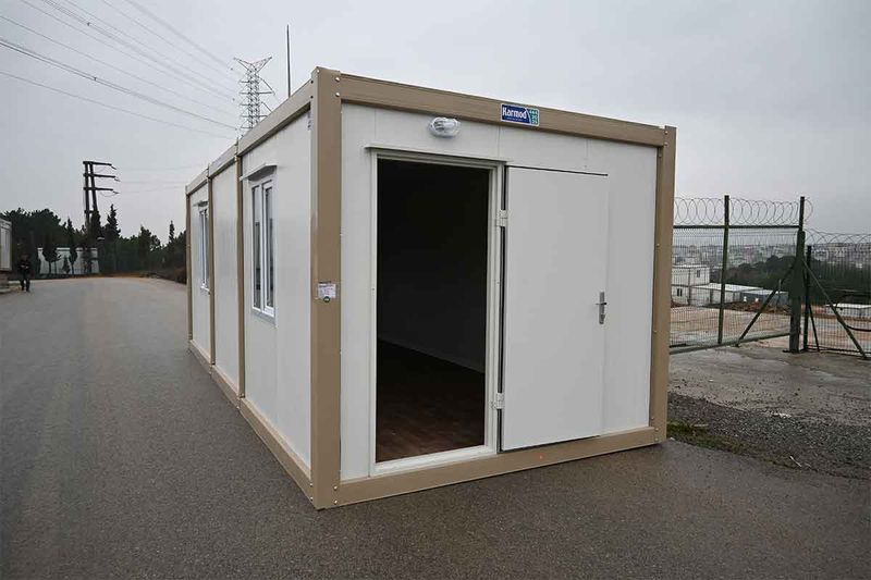 Standard container unit with its personnel door standing open, showing the wood-effect floor inside.